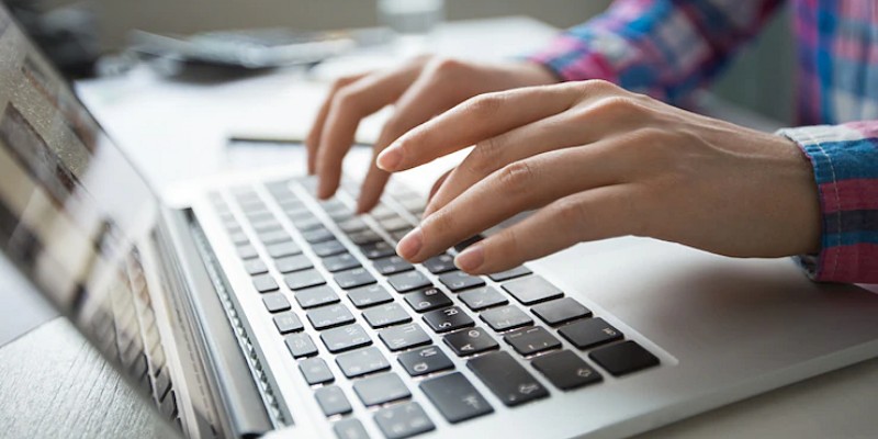 Ragazza con le mani sulla tastiera del notebook e pronta per scrivere – Investimenti online