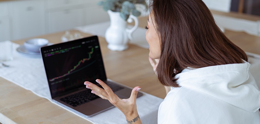 Trader contenta mentre osserva il grafico in crescita sul monitor del suo portatile – Come iniziare trading senza rischi